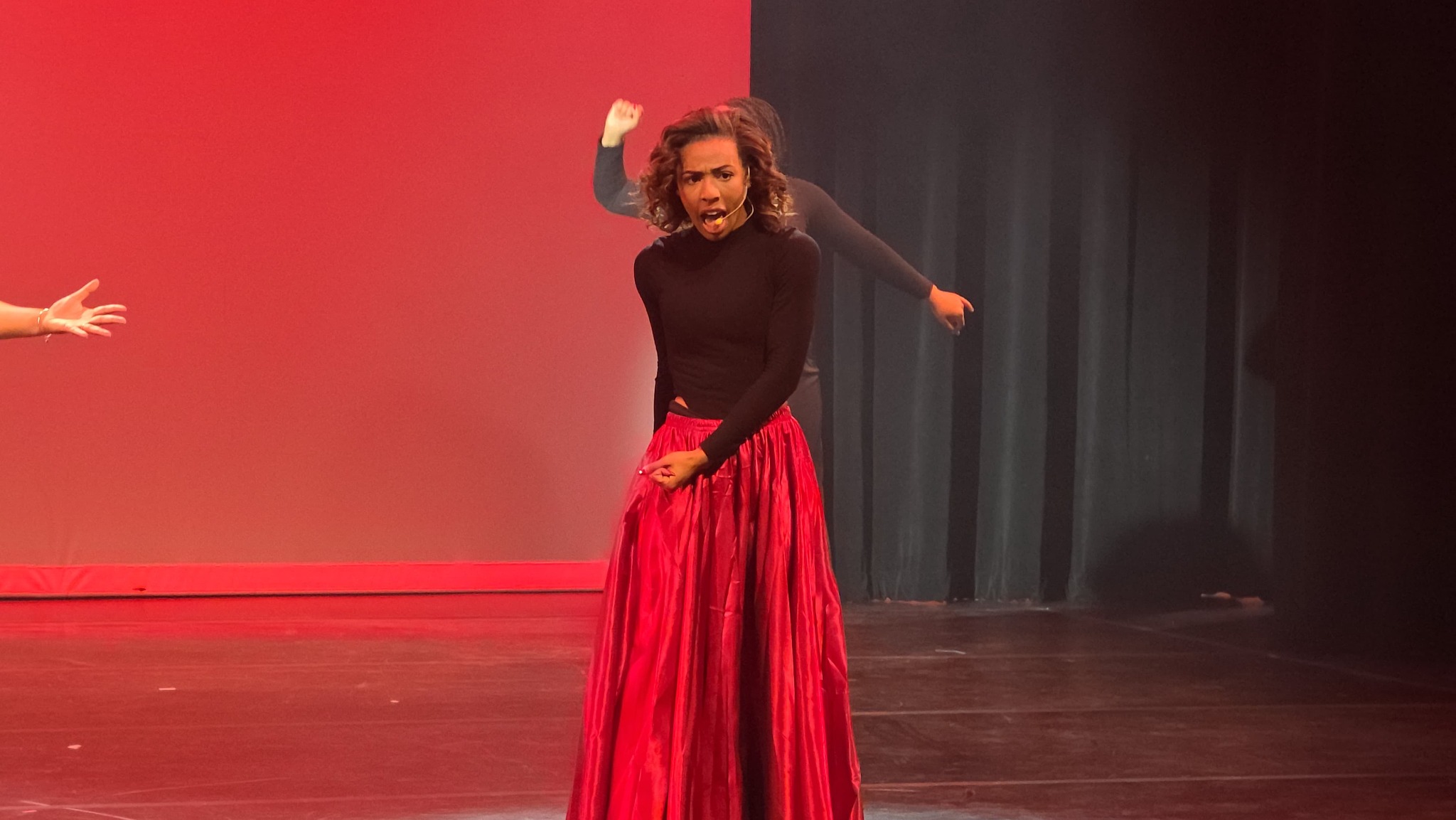 Live stage performance with red skirt
